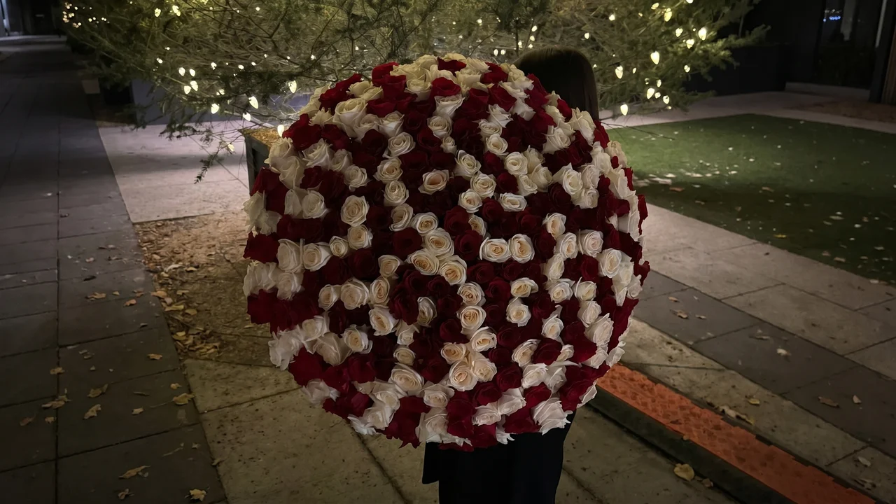 Wide view of a luxury flower delivery moment at a Boston residence, showing the elegant bouquet and the emotional doorstep experience.