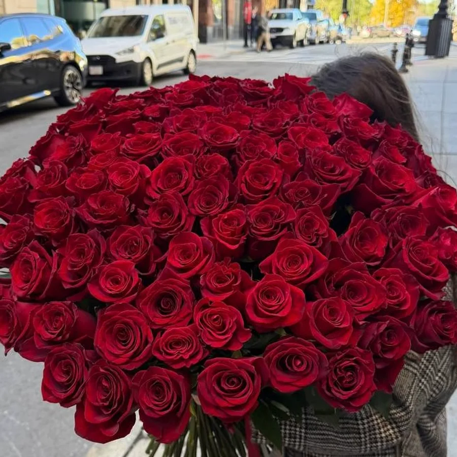 Large red rose bouquet carried outdoors on a Boston street