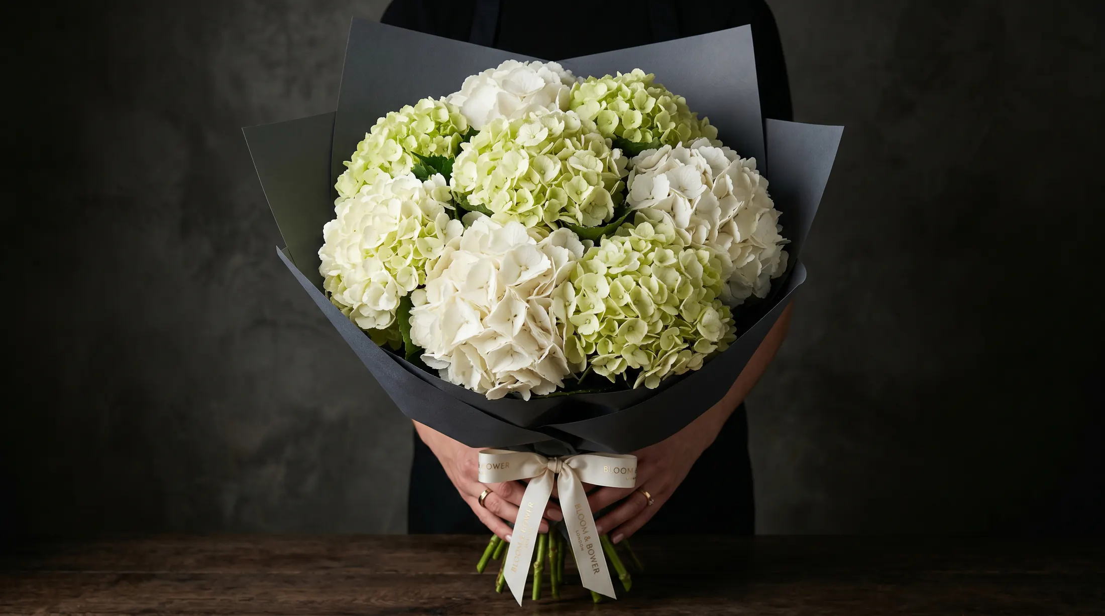 custom white hydrangea bouquet wrapped in black paper by Boston Flowers