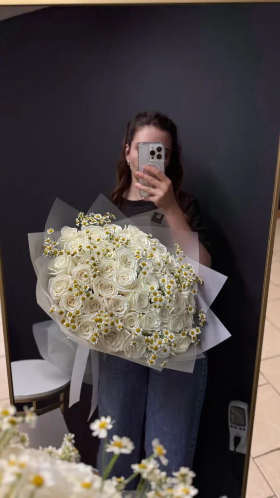 Woman holding the grand-scale Weston Lyric white rose and chamomile bouquet