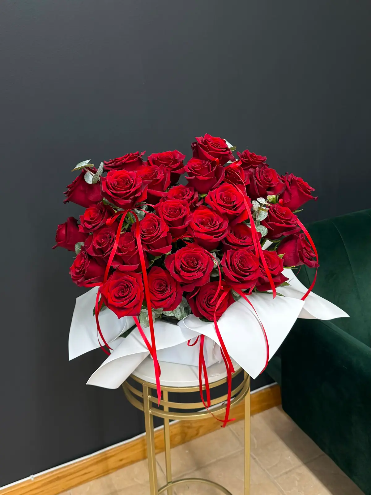 Commonwealth Crimson deluxe bouquet of deep red roses in white wrap with trailing red satin ribbons