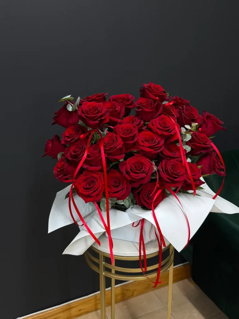 Commonwealth Crimson deluxe bouquet of deep red roses in white wrap with trailing red satin ribbons, view 2