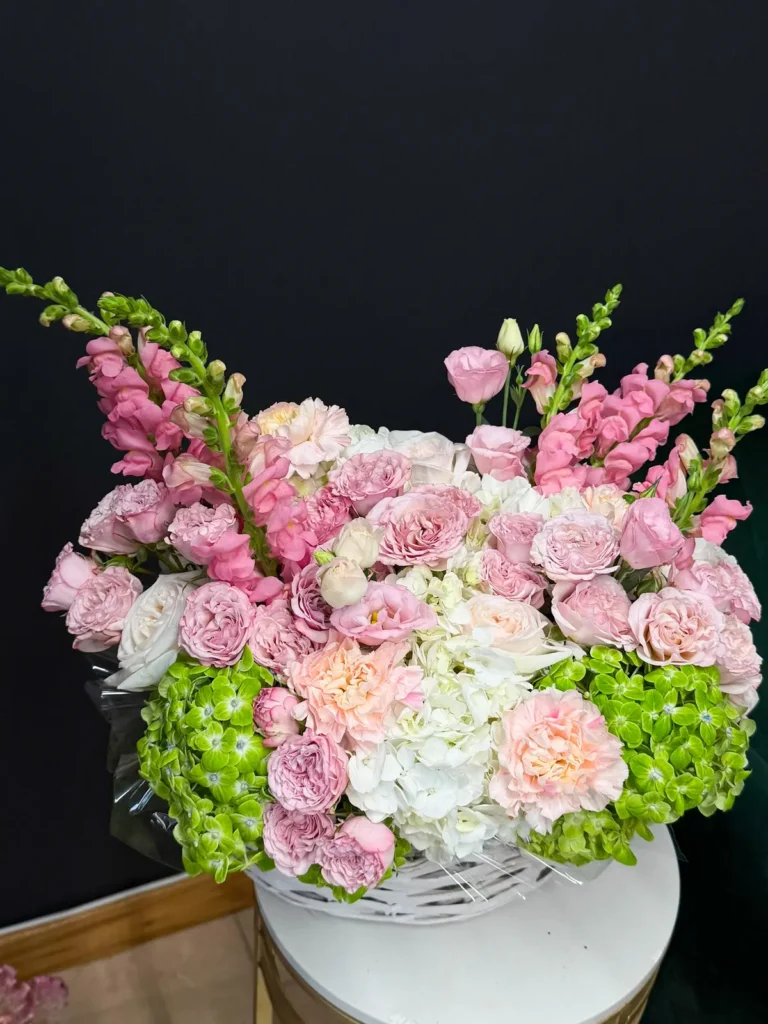 Pastel Symphony woven basket of blush garden roses, pink spray roses, white and green hydrangea and pink snapdragons, view 2