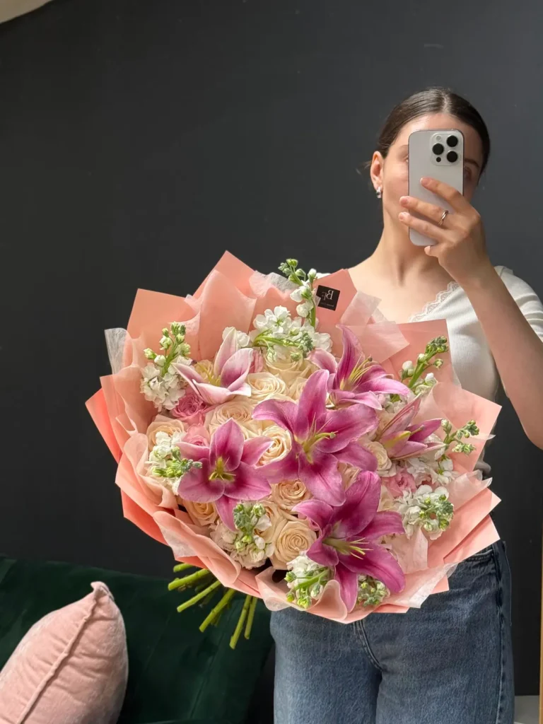 South End Stargazer bouquet of magenta Stargazer lilies, champagne roses and white stock in soft peach wrap, view 2